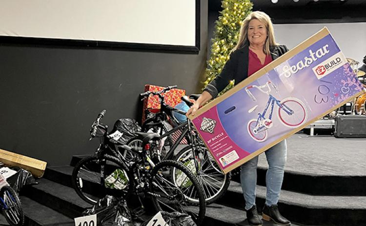 Cheryl Kennedy, associate pastor at The Bridge Church, holds one of the bicycles among the many gifts that have been donated for Family Connections’ White Christmas effort. The toys are labeled by families that have been adopted in this effort to provide Christmas to struggling families this year. Volunteers from around the county have worked in this effort. (Photo/Linda Erbele)