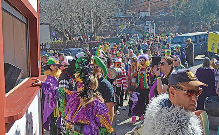 A long line of costumed celebrants visit the second Schnapp Stop, Cafe International, during the Fasching sidewalk parade Saturday. (Photo/Samantha Sinclair)