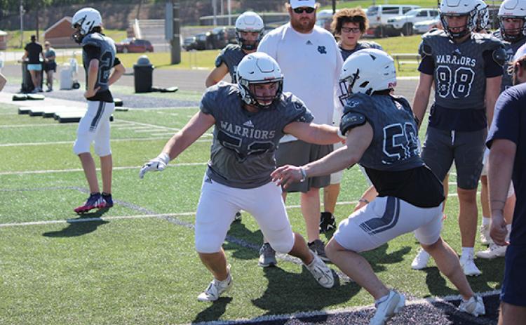  WCHS offensive lineman Tyler Autry gets in some padded work against Austin Garrett during an offensive line drill. 