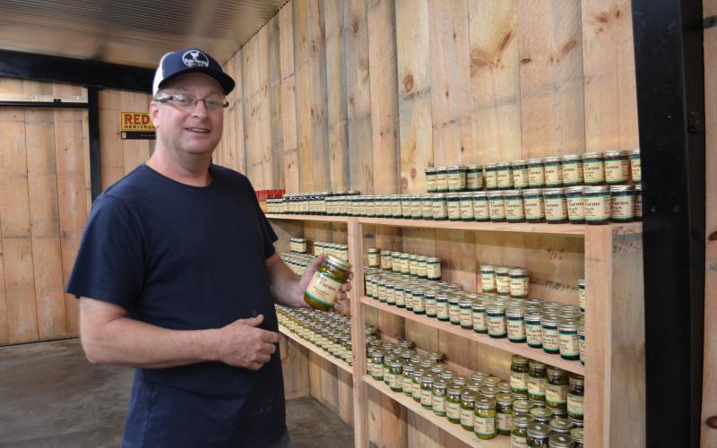 Mike Dyer shows off the moonshine pickles that are available at the store. These pickles have been very popular. (Photo/Stephanie Hill)
