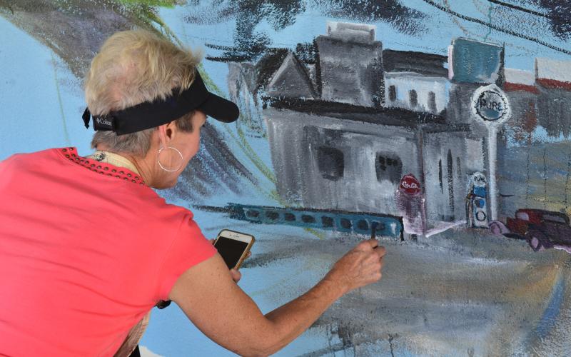 Anna Wilkins was focused on her painting of the new mural in Helen. (Photo/Stephanie Hill)