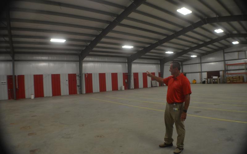 Mountain Education Charter High School Assistant Superintendent Tracy Sanford points to the back wall of the system’s new transportation and storage facility, where new bay doors will be installed. The building is the former site of Sautee Hard Cider on Helen Highway. (Photo/Wayne Hardy)