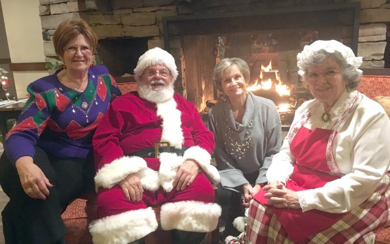At right (from left), Brenda Helton, Santa Claus, Carol Jackson and Mrs. Claus enjoy a chat by a fireplace in the Unicoi lodge. (Photo/Wayne Hardy)