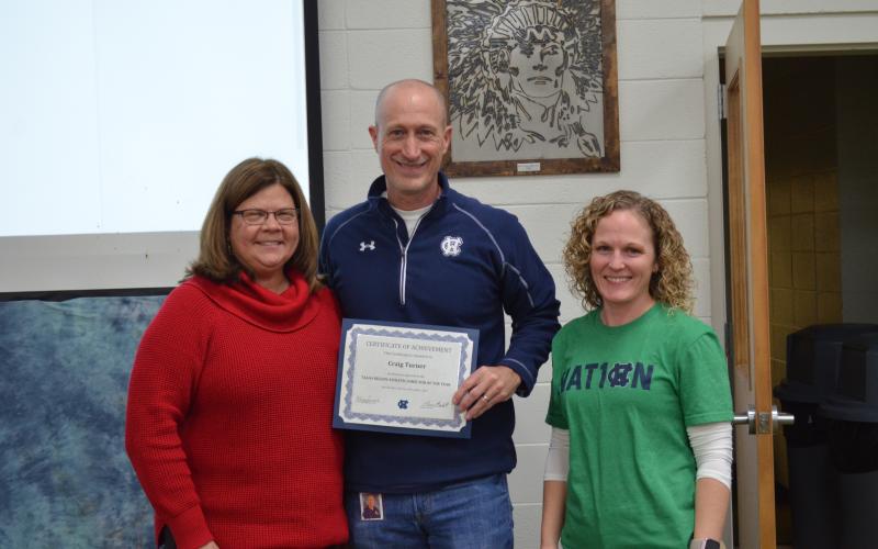 Superintendent Dr. Laurie Burkett, left, and WCHS principal Mary Anne Collier, right, present a certificate to Craig Turner. (Photo/Stephanie Hill)