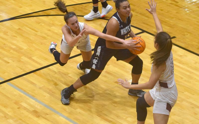 Dasha Cannon works in the lane between two defenders during Tuesday night's win over Chestatee. Cannon, a junior, was honored during the game for going over the 1,000-point total in her high school career. (Photo/Mark Turner)