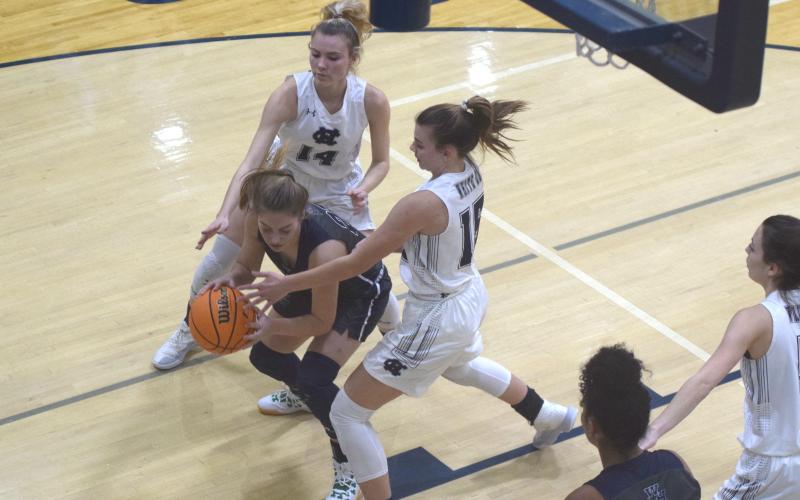 Naomi Crumley, left, and Ellie Gearing put some defensive pressure on West Hall's Amber Hughes during the tournament opener Tuesday night in Cleveland. (Photos/Mark Turner)