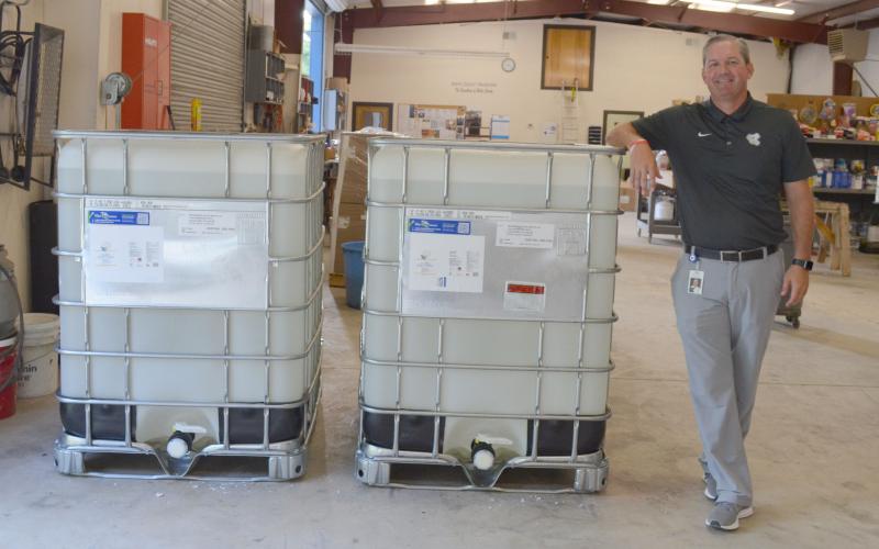 White County School System Assistant Superintendent Scott Justus shows off the 640 gallons of hand sanitizer the school system purchased for this year. (Photo/Stephanie Hill)