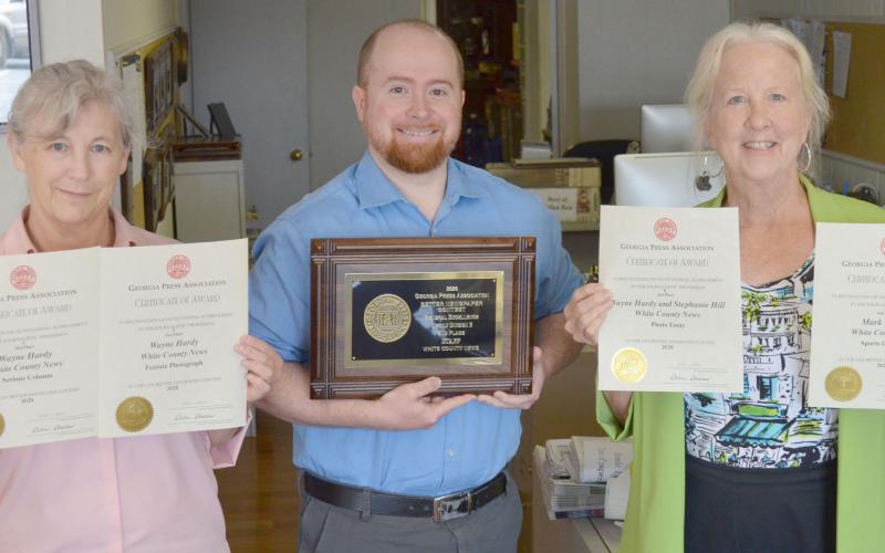 From left, White County News office manager Susan Egan, Editor & Publisher Wayne Hardy and marketing specialist Aileen Hood hold some of the newspaper’s recent awards from the Georgia Press Association Better Newspaper Contest.