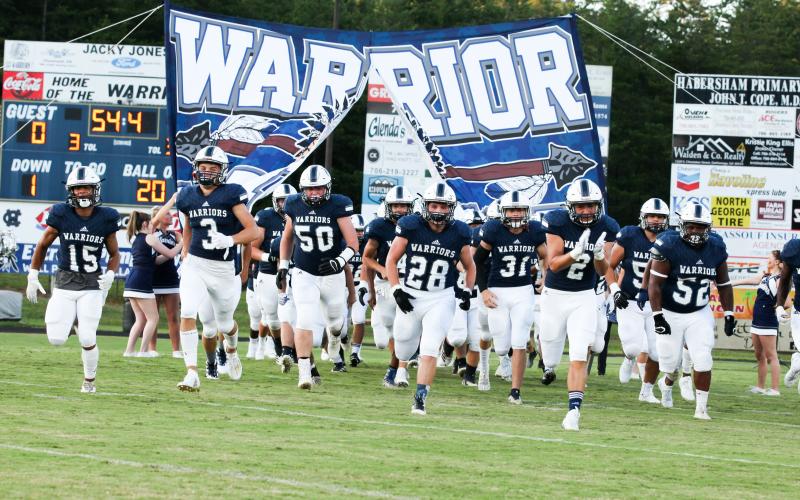 The Warriors, led by, from left, Kane Lowery, Bryson Cronic, Alex Garcia, Seth Stonecypher, Malachi Zellars, Clayton Rogers, and Jaquez Williams charge onto the field for the start of the 2020 season Friday night in Cleveland. (Photo/Staci Sulhoff)