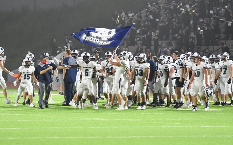 The WCHS players fly the Warrior flag moments after finishing off a 28-21 win over Habersham Central. (Photos/Tom Askew)