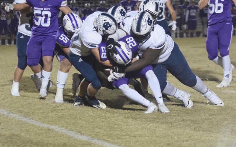 Riley Stancil, left, and Heaven Gholston, right, lead a pack of Warrior defenders as they smother Cherokee Bluff running back Jayquan Smith for a loss during the opening quarter of the regular season finale last Friday night in Flowery Branch. (Photos/Mark Turner)