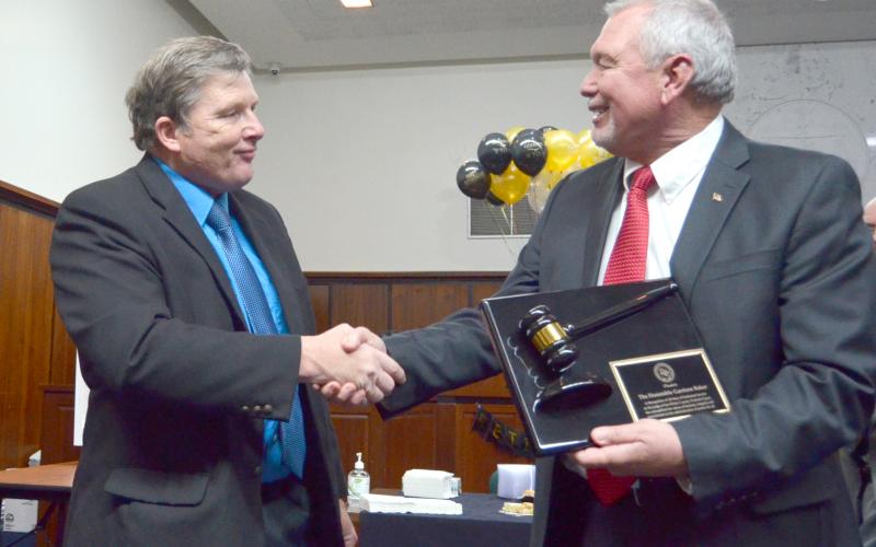 Probate judge-elect Don Ferguson shakes hands with Baker after presenting the retiring probate judge with an honor recognizing his longtime service in the office, on behalf of Georgia’s probate judges.