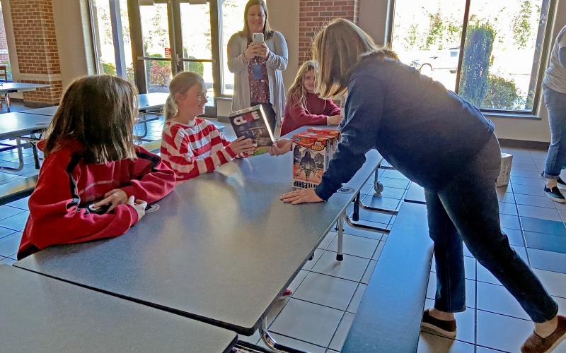 Students were all smiles as they received the games from Hasbro. Pictured is White County School System Superintendent Laurie Burkett giving a Clue game to a student. (Photo/Stephanie Hill)