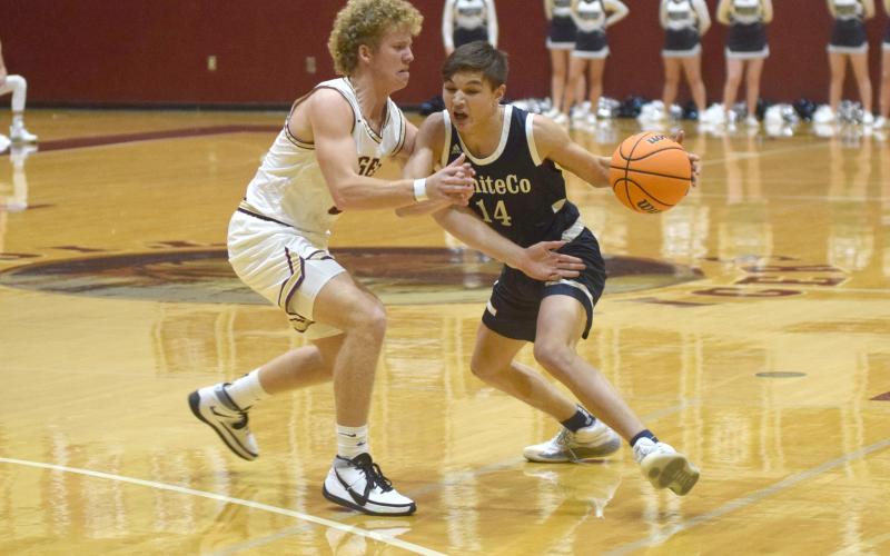 Jadon Yeh, right, shown working against Dawson County's Jaden Gibson, had a three-point play in the final 30 seconds of the game to lift the Warriors to a 59-58 win. (Photo/Mark Turner)