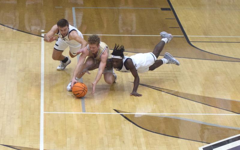 White County's Reece Dockery, left, and Silas Mulligan, and Dawson County's Jadon Gibson dive for a loose ball during the region title game Tuesday in Ellijay. (Photo/Mark Turner)