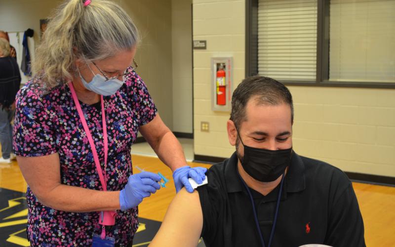 White County Middle School teacher Jack Fullerton waits as WCMS nurse Nancy Mixon administers a COVID-19 vaccine at the White County School System vaccine clinic March 11. (Photo/Stephanie Hill)