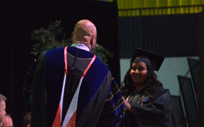 Clarissa Bran is greeted by TMU President Dr. Emir Caner as she walks the stage.