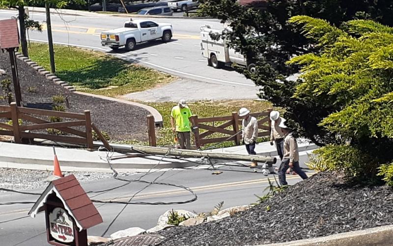 Workers exam the downed power pole. (Submitted photo)