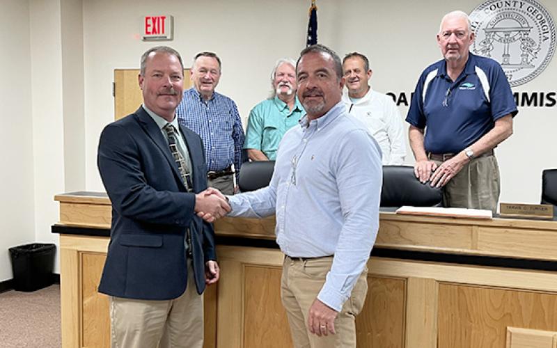 White County’s new interim county manager, Billy Pittard, left, shakes hands with Commission Chair Travis Turner at a called commission meeting to announce his employment May 8. Behind them, from left, are commissioners Terry Goodger, Craig Bryant, Lyn Holcomb and Edwin Nix. (Photo/Linda Erbele)