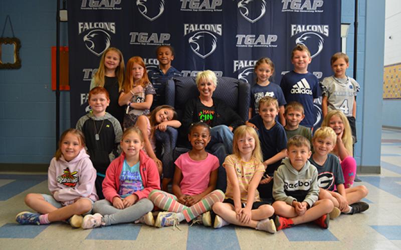 Kelli Usher is surrounded by her last class of students in front of the photo back drop at Tesnatee Gap Elementary School. (Photo/Samantha Sinclair)