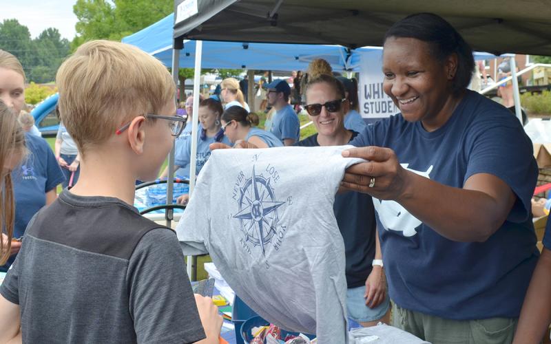 At Saturday’s Back to School Bash, White County Middle School Principal Nara Allen presents a t-shirt to student Gavin Gabhart as White County High School Principal Mary Anne Collier looks on. For more photos from the event, see Page 6A. (Photo/Samantha Sinclair)