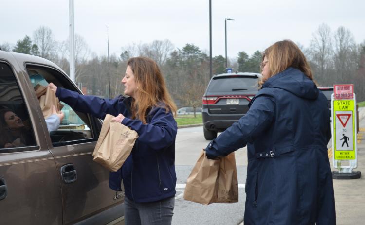 White County Schools Director of Student Accountability Jennifer King and Superintendent Dr. Laurie Burkett brought meals to a car in the drive-thru for a student feeding program, which is in place while schools are closed. (Photo/Stephanie Hill)