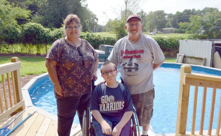 Trevor pictured at his pool with Lisa Hall, his nana, and Stanley Thompson, his papa. (Photo/Stephanie Hill)