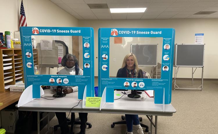 om left, poll workers Annie Sutton and Debora Palmer are all smiles as they help residents who are early voting at the voter registrar office. (Photo/Stephanie Hill)