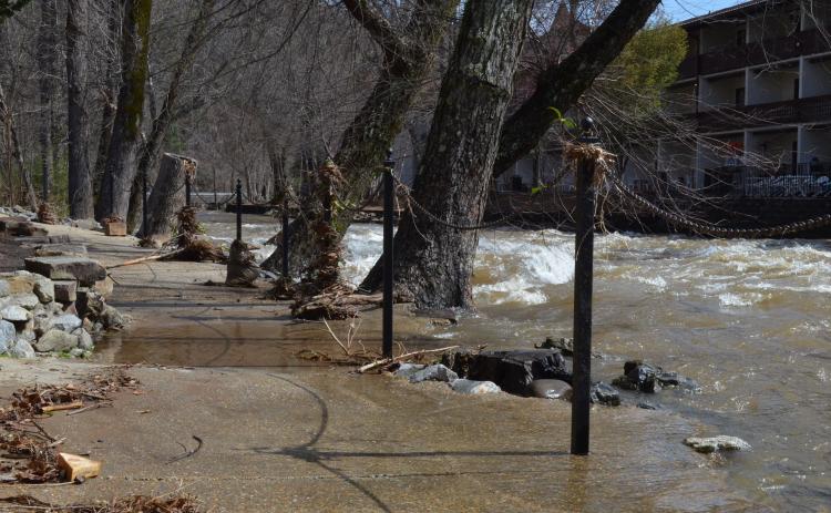 Even though it had gone down by Friday morning, the Chattahoochee River was still high and flowing onto the sidewalk in front of the Troll Tavern. (Photo/Stephanie Hill)