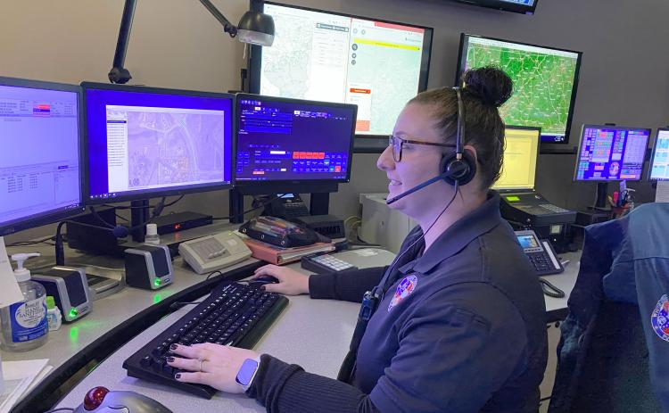 Kimberly Tallman demonstrates what dispatchers do when a call comes in. (Photo/Stephanie Hill)