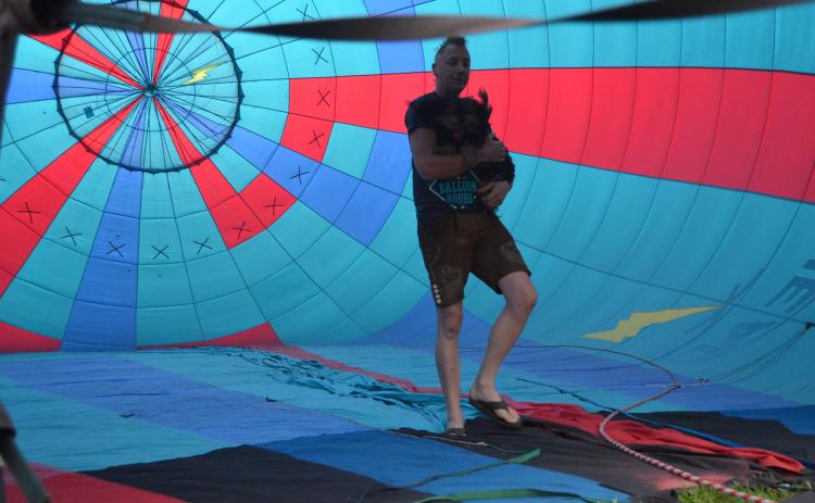 The 48th annual Helen to the Atlantic Balloon Race and Festival wowed the crowds during the showcase, held June 3-5. Pilot Jonathan Wright is shown inside a balloon during inflations last Thursday, holding his dog, Wicket. (Photo/Wayne Hardy)