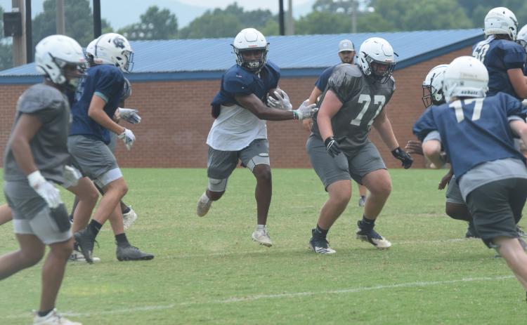 Zion McMullen, left, finds some running room off a block from Cameron Godfrey during Tuesday's practice session. The Warriors scrimmage East Forsyth next Friday night. (Photo/Mark Turner)