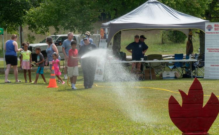 A youth had a chance to test out a fire hose with the help of a local firefighter at a previous Touch-A-Truck event.