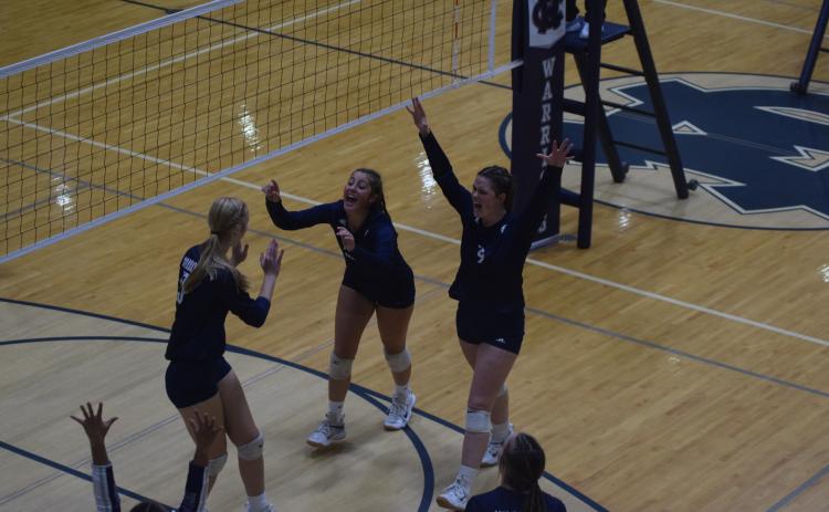 Claire Beckman, left, Linsey Burke, and Abbie Rankl celebrate a point during the Senior Night match against Tallulah Falls School. (Photo/Mark Turner)