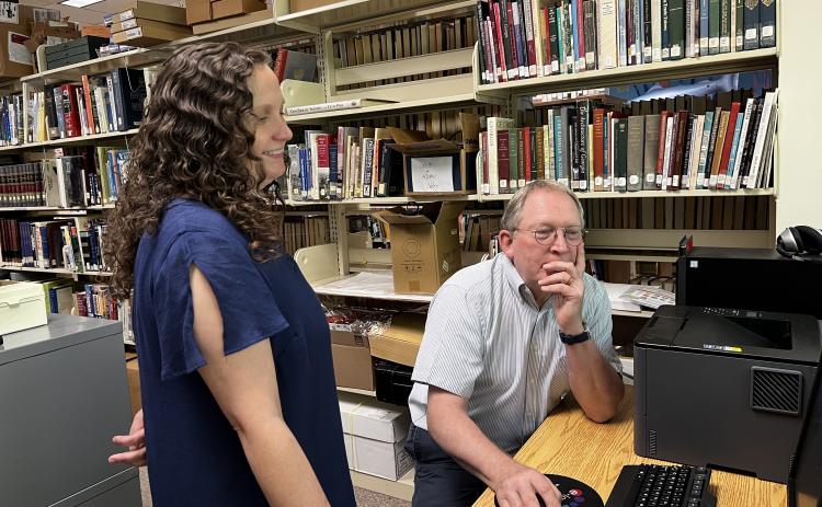 Michael Humphrey, retiring program manager at the Cleveland library, points out the intricacies of the ScanPro microfiche reader to the new program manager, Emily McConnell.