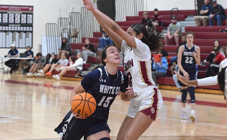 Naomi Roberts tries to drive past Hebron Christian's Aubrey Beckham during the state tournament game Tuesday night in Dacula. (Photo/Mark Turner)