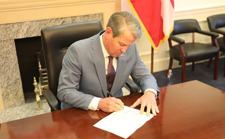 Gov. Brian Kemp signs a $1 billion state income tax rebate late Tuesday. (Photo/Capitol Beat)