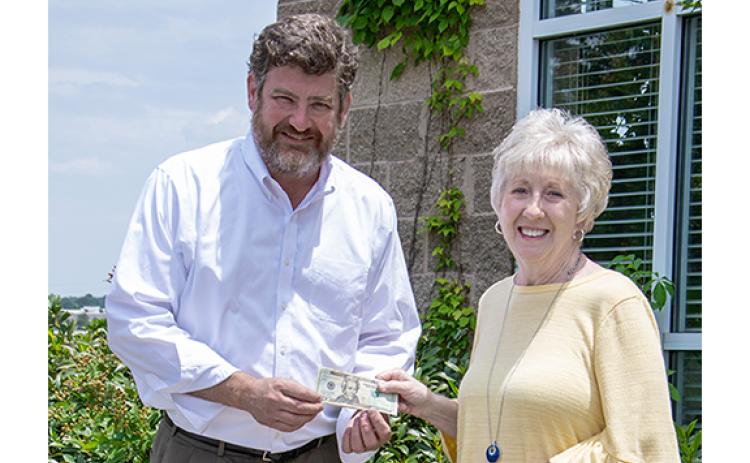 Cornelia resident Donna Shirley receives her $100 prize money from Alan NeSmith, Community Newspapers Inc. chairman. Shirley’s photograph of the double waterfalls that make up Anna Ruby Falls graces the cover of the 2023 summer edition of The Mountain Traveler magazine. (Photo/Kimberly Brown)