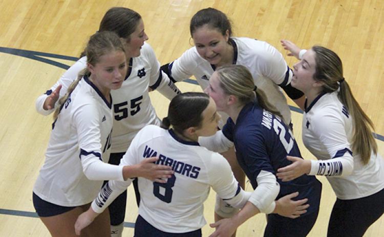 The Lady Warriors celebrate a point during a recent match at WCHS. (Photo/Mark Turner)