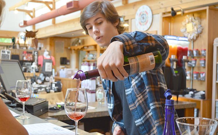 Tristan Harris pours a sample of Concord, a sweet wine from Habersham Winery, during a wine tasting last week. (Photo/Samantha Sinclair)