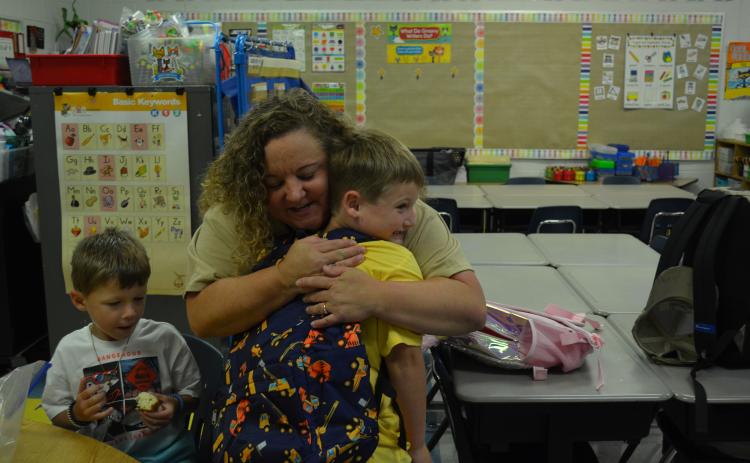 Tesnatee Gap First Grader Fischer Miller gives Suzanne Grisham a hug while stopping in his former kindergarten teacher’s classroom on the way to his class on the first day of school. (Photo/Samantha Sinclair)