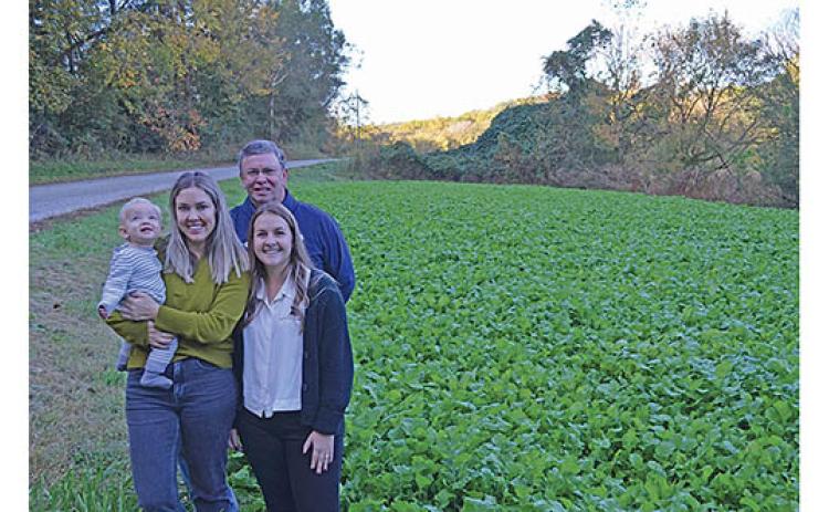 Marci Brown with Finn, Charlie Thomas and Haley Thomas are ready to welcome folks to gather turnip greens at their field on Charlie Thomas Road. (Photo/Samantha Sinclair)