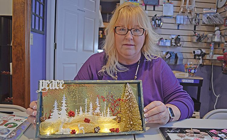 Owner Melanie Rosdahl shows a decor piece crafters could learn to make at a recent class at Scrappy Shak. (Photo/Samantha Sinclair)