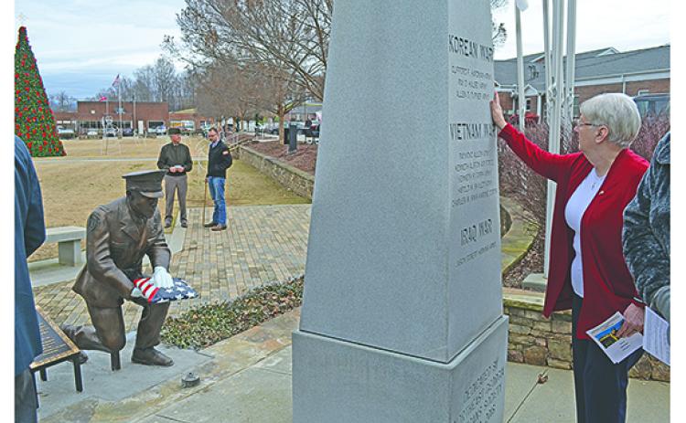 Terri Crumley brushes her hand over the side of the White County War Memorial where her brother’s name is etched as the new Families of the Fallen monument faces the memorial. (Photo/Samantha Sinclair)