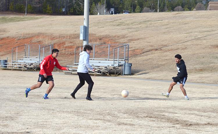WCHS students Bryan Lozada, Colin Fernandez and Carlo Penaloza play soccer with friends at Tesnatee Park in 31 degree weather Tuesday afternoon while school was closed. (Photo/Samantha Sinclair)