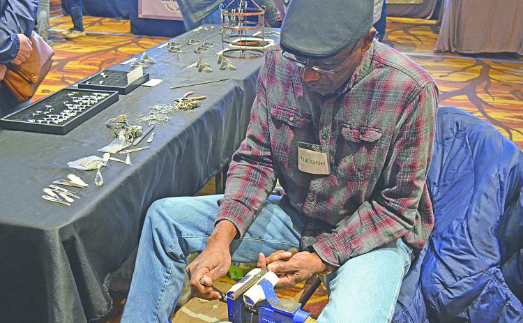 Nathaniel Williamson sizes a ring for a customer at his booth at last year’s Fireside Arts and Crafts Show at Unicoi State Park and Lodge. (file  photo)