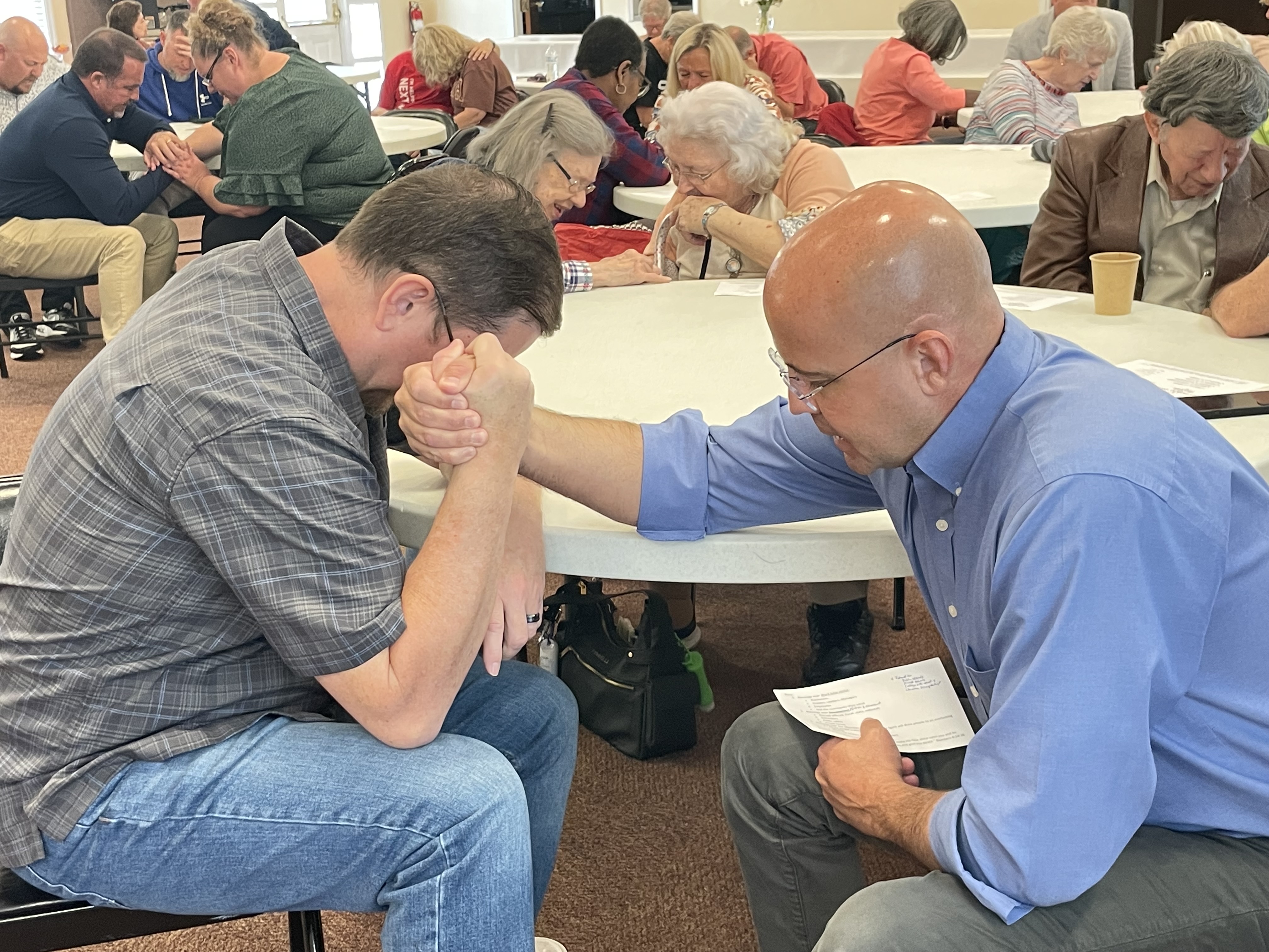 Marc Turner (right), pastor at the Cleveland Worship Center, clasps hands with Jeff Groves, pastor of the Bridge Church, during last week’s National Day of Prayer event at Cleveland First Methodist Church.  (Photo/Jerry Grillo)