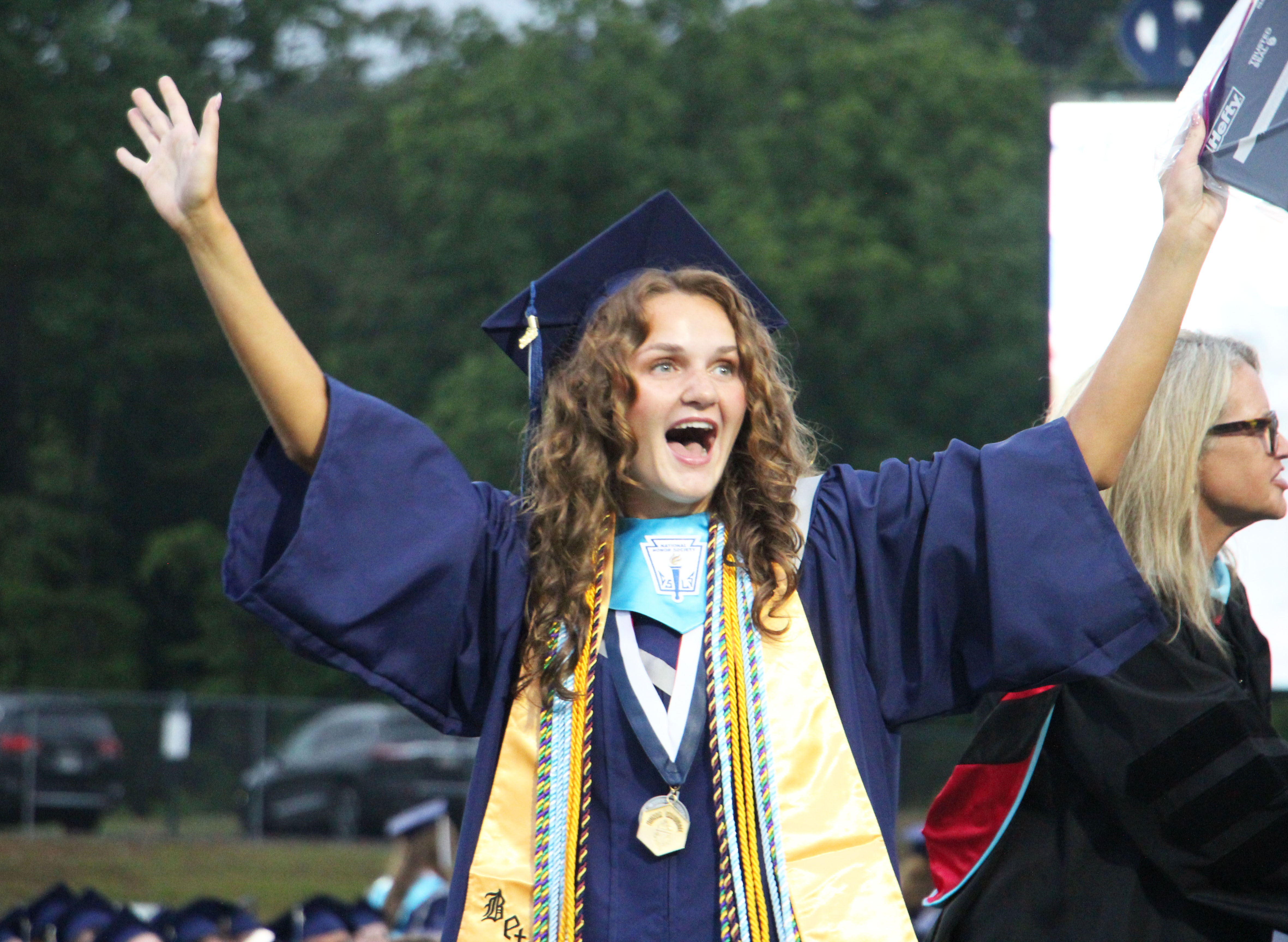 Caroline Tatum throws her hands in the air in celebration after receiving her diploma during the 2026 White County High School graduation ceremony. CARLY HENDERSON/WCN