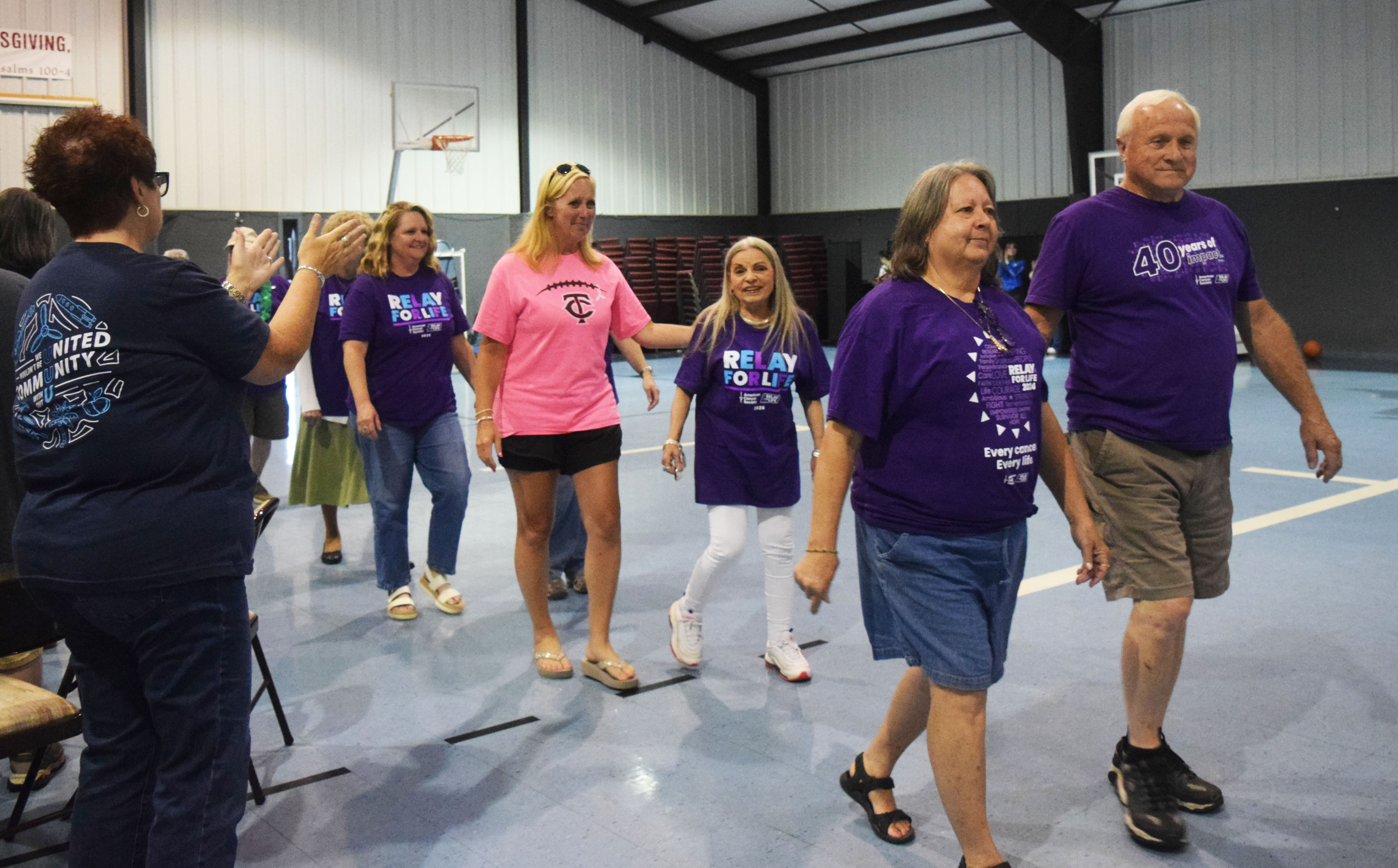 Supporters applaud cancer survivors during the White County Relay for Life on May 29. Brandy Roquemore, center left, and Brenda Jolly walk behind Rita and Chris Burdett. DENISE ETHERIDGE/WCN