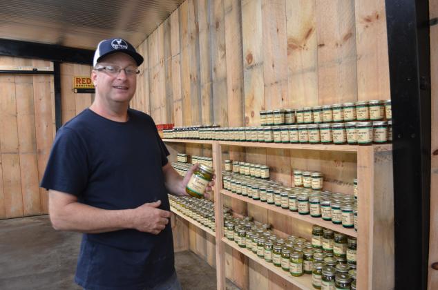 Mike Dyer shows off the moonshine pickles that are available at the store. These pickles have been very popular. (Photo/Stephanie Hill)